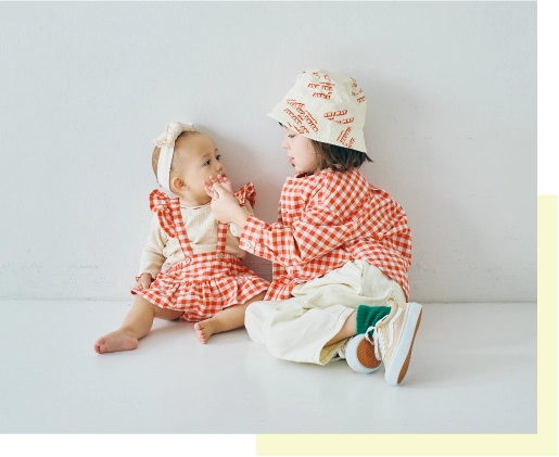 おそろいのギンガムチェックのアイテムを着用したモデルの2人の画像