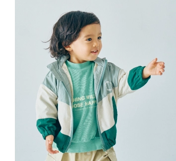 緑のウィンドブレーカーを着用している90cm男の子モデルの画像