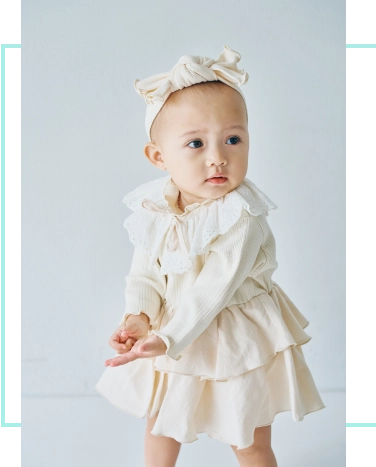 アイボリーのロンパスを着用したベビーモデルの画像