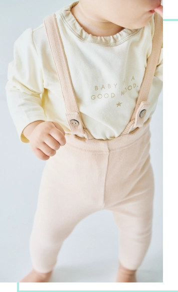 アイボリーのロンパスを着用したベビーモデルの画像